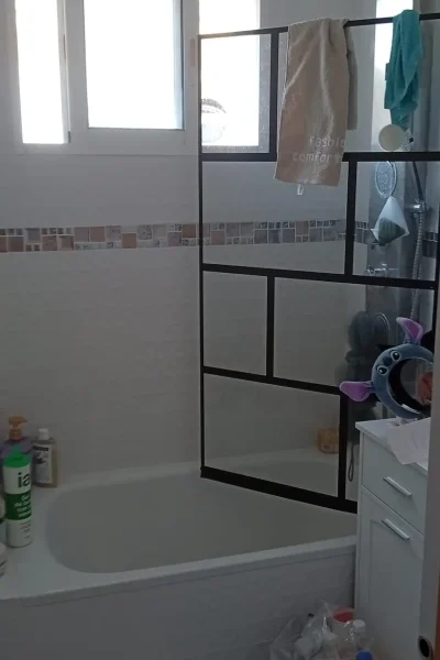 Reforma de baño en Málaga con bañera, mampara de perfilería negra estilo industrial y columna de ducha termostática por REFORMAS A Plomo y Nivel